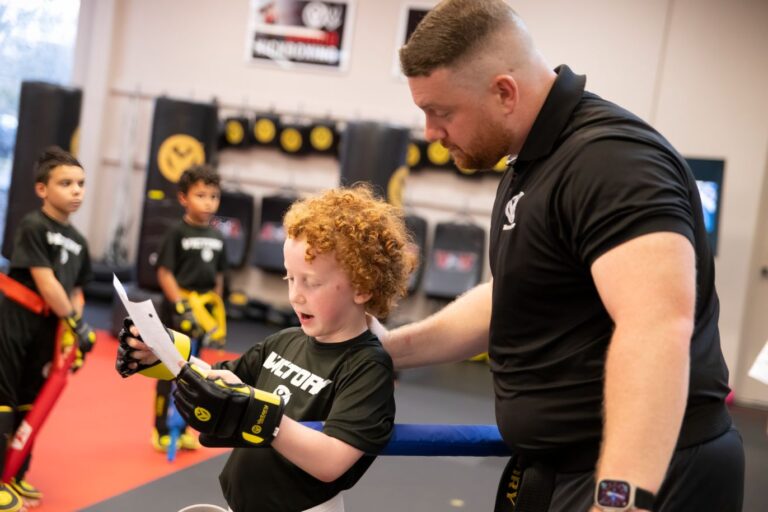 Martial Arts Instructor and a Boy Looking at The Paper With Instructions at Victory MA near Bandera, TX