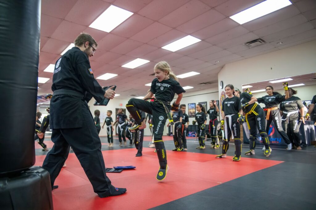 A girl Practices Kicking With her Instructor in Victory Martial Arts Longwood, FL
