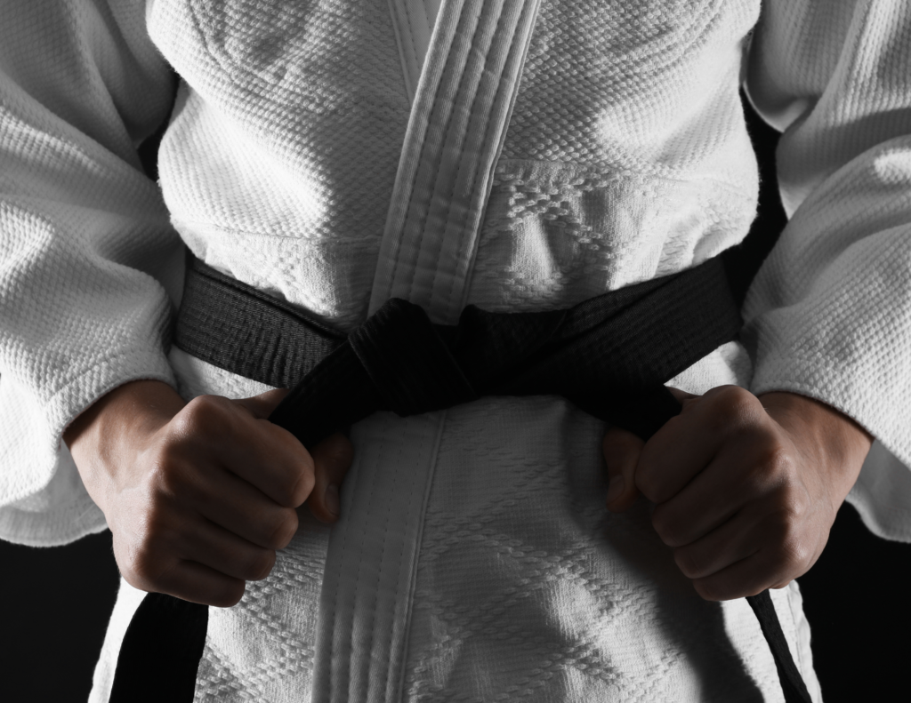 Person In White Martial Arts Kimono With a Black Belt