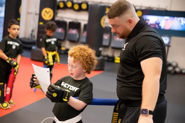 Boy Reading the Karate Training Program With His Instructor in Hardy Oak, Texas
