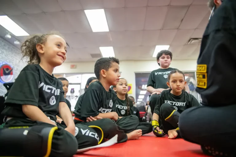 Kids Sitting on a Mat and Listening to Their Karate Instructor in Ocoee, Florida